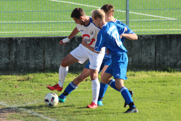 Robin Karolus, zweifacher Torschütze für den SV Rohrbach/S., schirmt den Ball vor zwei Waldangellocher Gegenspielern ab