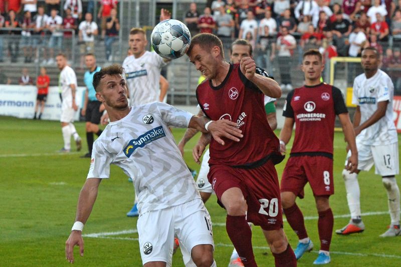 Nürnbergs Lukas Jäger (Nr. 20) im Kopfballduell mit Sandhausens Leart Paqarada (li.)