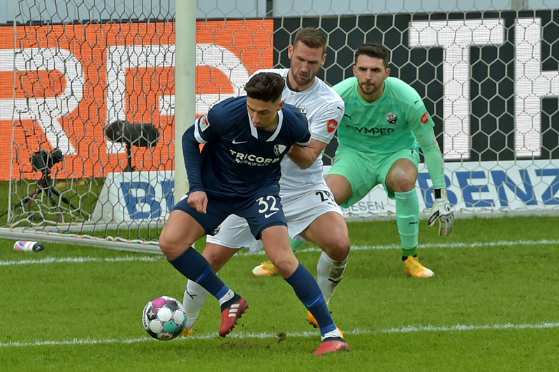Bochums Zulj (vorne) im Zweikampf mit Sandhausens Paurevic. Im Hintergrund verfolgt gespannt SVS-Keeper Kapino die Strafraumszene